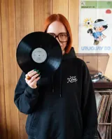 Canguro oversize color negro con capucha y bolsillo frontal tipo canguro. Presenta un pequeño logo bordado en color blanco en el pecho.