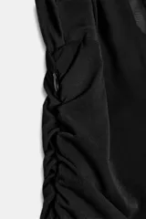 Vestido midi negro de cuello alto y sin mangas, con detalle drapeado en la parte superior y falda plisada. Incluye forro interior con tirantes finos ajustables y cierre lateral con cremallera oculta.