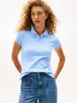 Chomba de algodón y elastano color celeste claro, de corte slim, con cuello tipo polo y cartera de dos botones. Presenta el logo script de Tommy Hilfiger bordado en el pecho y la bandera de Tommy Hilfiger bordada en la manga.