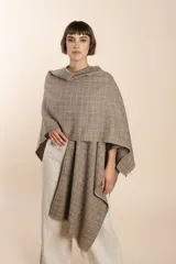 Ruana de lana fina color crudo con terminación envivada.