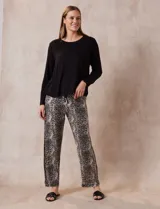 Conjunto de pijama marca René Rofé, compuesto por remera negra de manga larga con bolsillo en el pecho y pantalón largo con estampado animal print, cintura elastizada y lazo de ajuste.