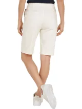 Pantalón corto blanco con cinturón de rayas horizontales rojas, blancas y negras, con hebilla metálica.