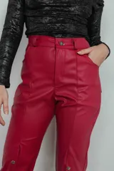 Pantalón de cuero sintético color rojo, de tiro alto y corte acampanado, con bolsillos delanteros y traseros, y botones metálicos a lo largo de la pierna.