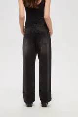 Pantalon jean de corte recto y tiro medio, con un lavado desgastado y un dobladillo ancho en la parte inferior que deja ver el revés de la tela con costuras en contraste.