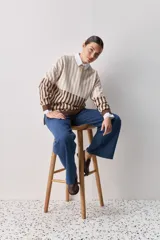 Sweater de tejido jacquard con diseño de rayas verticales en tonos rojo, blanco y azul. Presenta cuello redondo, hombros caídos y puños en contraste de color azul.