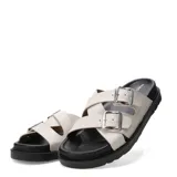Sandalias Miss Carol modelo Brix, color marfil, con dos tiras cruzadas ajustables mediante hebillas metálicas plateadas y suela plana de goma negra.
