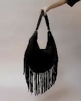 Cartera tipo hobo de gamuza color beige, con diseño amplio y detalle de flecos largos en todo el contorno. Cuenta con un asa superior con pespuntes artesanales y cierre principal.