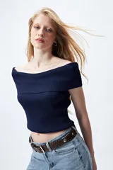 Top tejido de punto acanalado color blanco, con escote bardot que deja los hombros al descubierto.