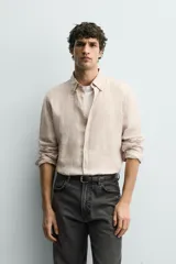 Camisa celeste de lino de corte regular fit, con cuello abotonado, manga larga y cierre frontal de botonadura.