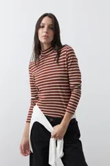 Polera de cuello alto con diseño de rayas horizontales en color azul marino sobre fondo blanco, confeccionada en tejido de punto con mangas largas.