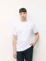 Remera blanca de manga corta y cuello redondo, confeccionada en algodón pesado.