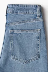 Jean de tiro alto con corte wide leg, confeccionado en denim de algodón con leve elasticidad. Presenta diseño clásico de cinco bolsillos, cierre frontal con botón y acabado en tono azul medio.