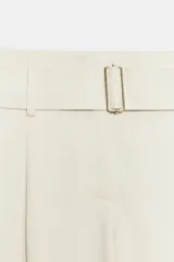 Pantalón de tiro alto con diseño de pierna ancha y pinzas frontales. Incluye un cinturón integrado del mismo tejido con hebilla metálica, bolsillos laterales ocultos y cierre frontal con cremallera y ganchos.