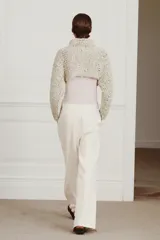 Jersey cropped de punto con textura de cinta entrelazada, cuello subido y manga larga.