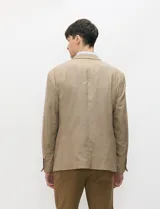 Blazer de medio forro, color marrón tostado, con solapas de muesca, cierre frontal de dos botones y bolsillos con solapa. Presenta silueta estructurada.
