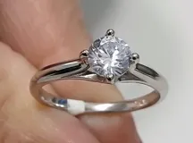 Anillo de plata 925 con piedra circonia central de corte redondo con engarce de cuatro puntas y diseño de banda clásica.