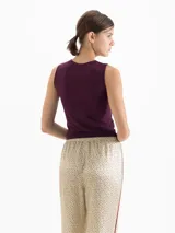 Musculosa de cuello redondo y silueta minimalista, confeccionada en una suave mezcla de poliamida y elastano que ofrece un calce confortable y una gran adaptabilidad al cuerpo. Su diseño sin mangas con hombros sutilmente encajados la convierte en una prenda básica de alta calidad.