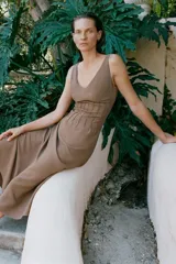 Vestido midi marrón de punto con escote en V y tirantes finos, con detalle de costuras verticales en el talle y falda acampanada.