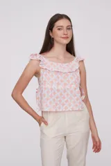 Blusa de algodón con estampado geométrico en tonos rosado y blanco, diseño holgado con escote bote y detalle de volados en los hombros.