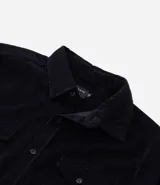 Camisa de hombre color verde oscuro, confeccionada en terciopelo, con cuello clásico, manga larga y dos bolsillos frontales con solapa y botón. Cierre frontal con botones.