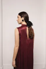 Vestido largo color ocre con estampado de cuadrados dorados, cuello alto y corte amplio. Incluye viso liso al tono.