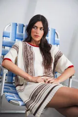 Vestido corto tejido a rayas horizontales en tonos beige y blanco, con cuello redondo y mangas cortas.