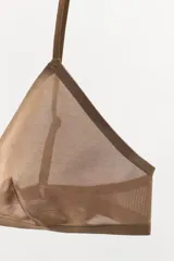 Bralette triangular de diseño minimalista confeccionado en tejido de poliamida semitransparente. Presenta escote en pico, tirantes finos ajustables y cierre posterior con gancho metálico.