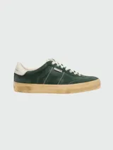 Championes de gamuza color verde oscuro con suela de goma envejecida, cordones blancos y detalle de talón en cuero blanco.