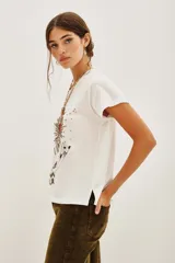 Remera blanca de algodón con estampado frontal de manos en posición de rezo rodeando un corazón rojo con rayos dorados.