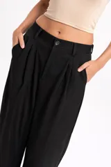 Pantalón sastrero de tiro alto con corte amplio y pinzas frontales. Presenta bolsillos laterales y cierre frontal con botón.