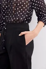 Pantalón recto negro de tiro alto con cierre trasero invisible y bolsillos laterales.