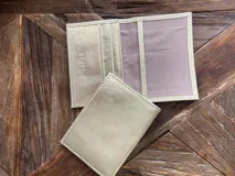 Tarjetero de cuero vacuno color dorado, con ranuras para tarjetas y bolsillo exterior en la parte trasera. Marca Bretoni.