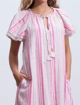 Vestido corto de lino a rayas verticales rosas y blancas, con cuello fruncido, escote en V con lazo de ajuste y mangas cortas con puntilla de crochet.