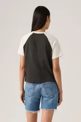 Remera raglan con mangas cortas blancas y cuerpo negro. Presenta un estampado frontal con un caballo salvaje en un círculo rojo y el texto "Levi's Work by all Cowboys".