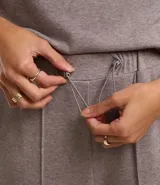 Pantalón wide leg de chenille color gris, con cintura elástica, trabillas para cinturón y flecos verticales.