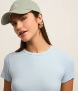 Blusa básica de manga corta y cuello redondo, confeccionada en viscosa texturizada de canalé con elastano y detalle de terminación ondulada en el bajo.