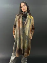 Tapado largo de lana merino con teñido tie-dye en tonos marrones, amarillos y grises. Presenta corte especial en los hombros y bolsillos laterales.