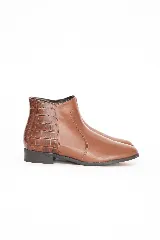 Botineta de cuero color chocolate con diseño clásico y talón con textura efecto cocodrilo. Cuenta con suela baja y cierre lateral interno.