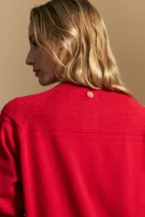 Cardigan de tejido de punto color rojo, con cuello redondo, cierre frontal de botones al tono y puños acanalados.