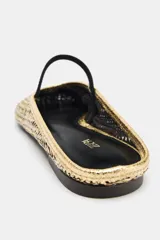 Bailarina destalonada dorada con efecto metalizado y cuerpo trenzado. Tiene una tira elástica negra en el empeine y acabado en punta redonda. La suela mide 1 cm.