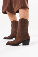 Bota de caña media de cuero marrón con acabado texturado, diseño de estilo western, tiradores laterales y taco medio cuadrado.
