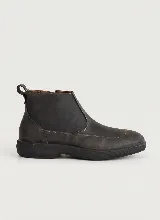 Bota corta de cuero negro con textura granulada, diseño de puntera reforzada y suela de goma gruesa con relieve estriado. Cuenta con cierre lateral y tirador en la parte trasera.