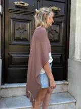 Ruana tejida en color marrón mocca, con diseño de punto liso y detalle de flecos en los extremos.