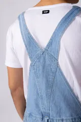 Jardinero de jean en color celeste claro con lavado desgastado. Presenta un diseño clásico con bolsillo frontal en el pecho, breteles regulables con hebillas metálicas y corte relaxed de pierna recta.