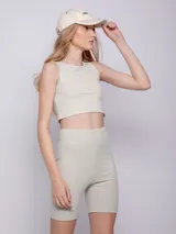 Calza ciclista negra de tela brillante con textura acanalada y elástico en la cintura.