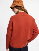 Sweater de tejido de punto color ladrillo. Escote en v y mangas largas de sisa caída. Confeccionado en lana.