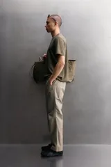 Pantalón de corte tapered fit color beige, confeccionado en tejido ligero de algodón con estructura rip stop. Cuenta con bolsillos de plastrón delanteros con acceso curvado, pinzas en las rodillas para mayor movilidad, y cierre frontal con cremallera y botón a presión.