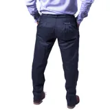 Pantalón de vestir azul marino, de corte recto, con bolsillos laterales y traseros. Se ajusta a la cintura con cinturón de cuero marrón. Tiene un cierre con botones en el tobillo.