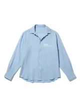 Camisa de lino rayada en tonos celeste y blanco, con cuello y botones frontales. Presenta un estampado en el frente y la espalda.