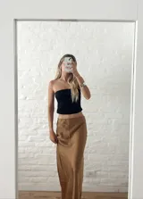 Pollera larga de seda color caramelo con elástico en la cintura.